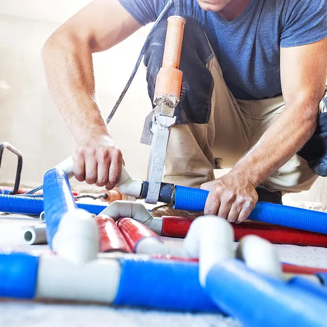 plumber fitting pipes on flooring